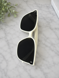     Women’s oversized white square sunglasses with black UV lenses.