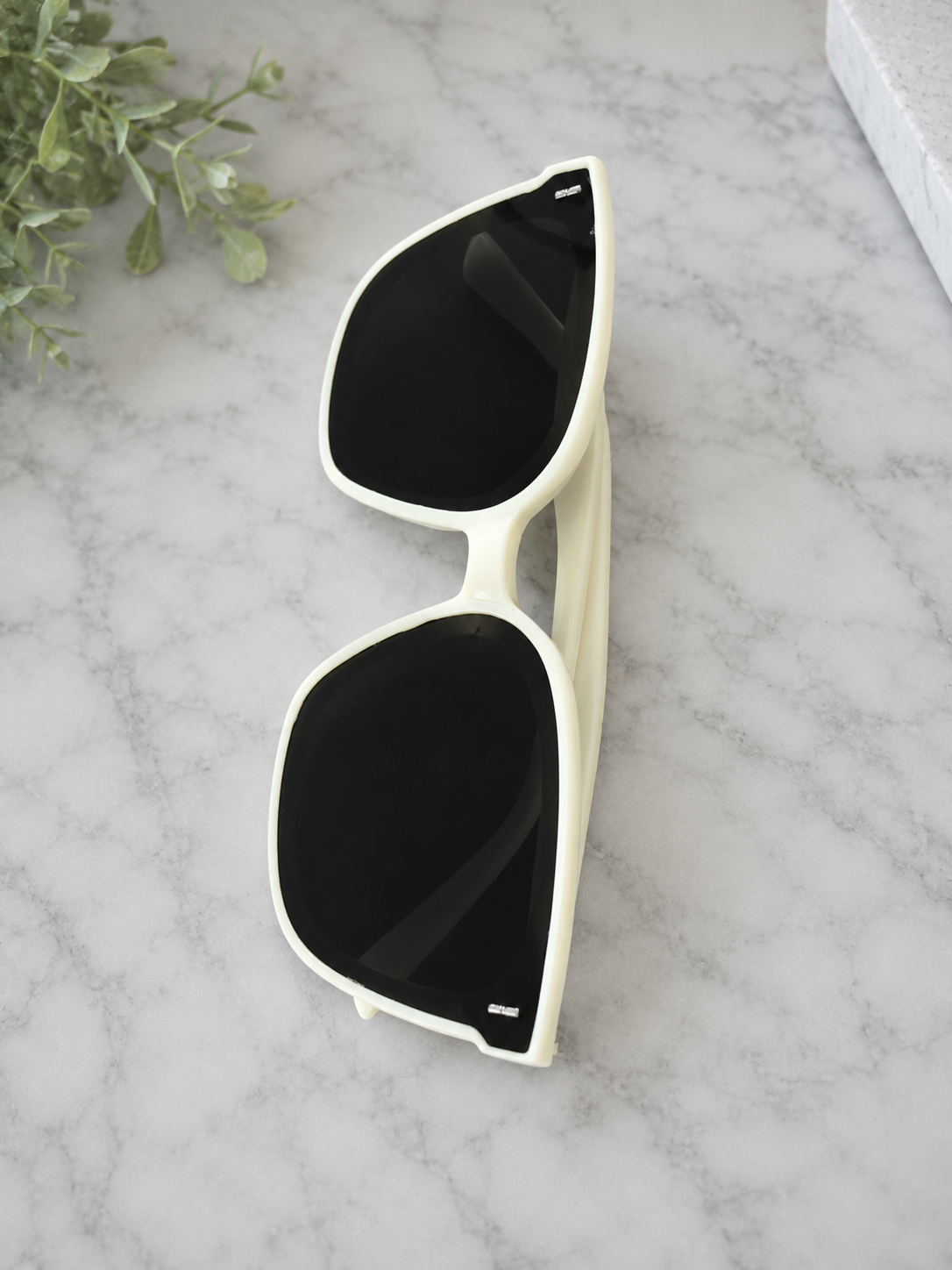     Women’s oversized white square sunglasses with black UV lenses.